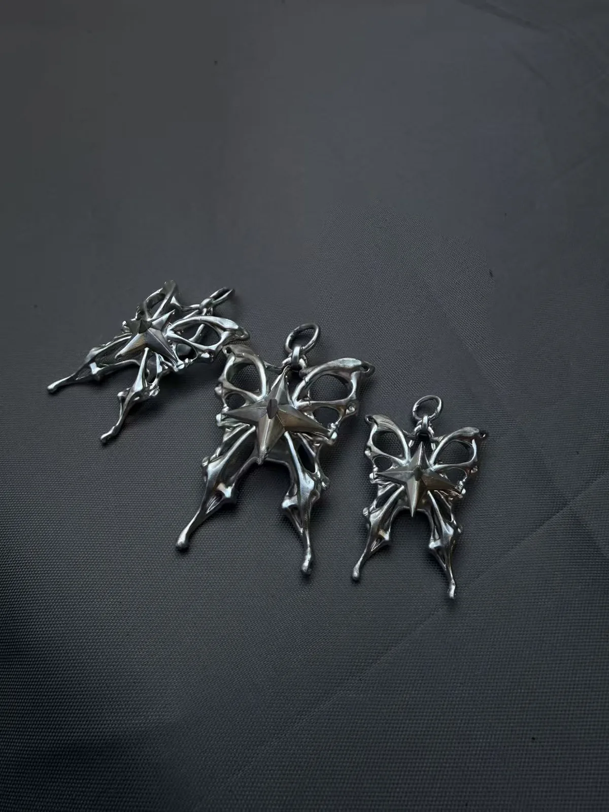 Metal charm prototypes on dark fabric